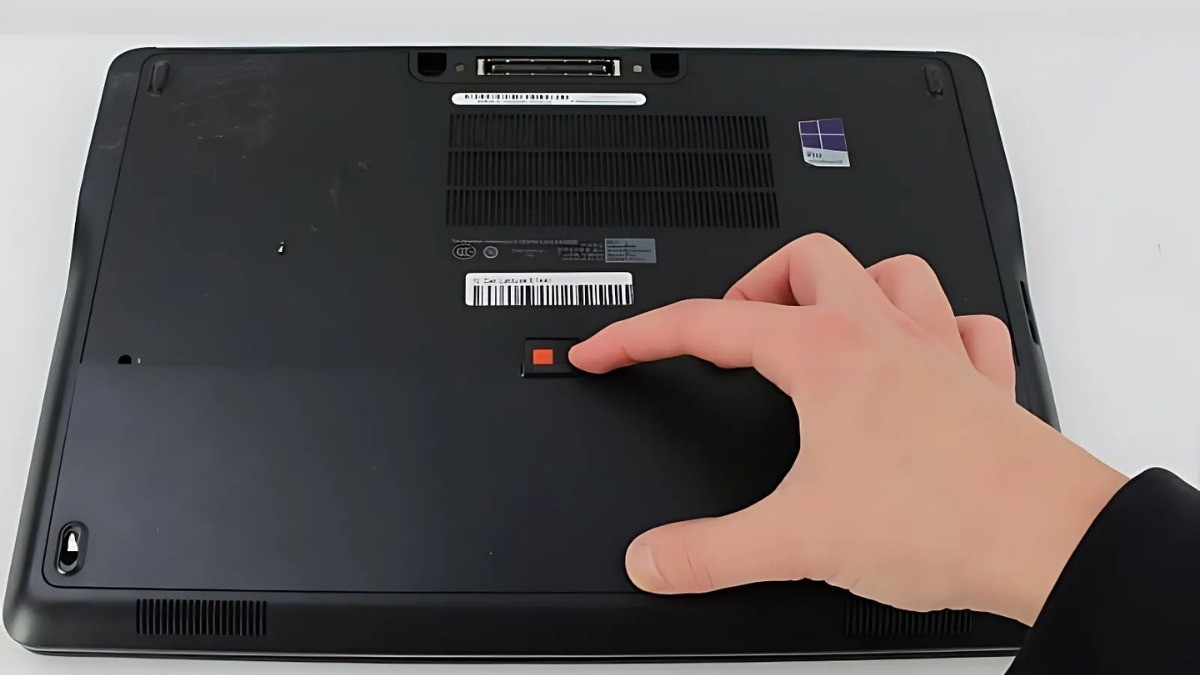 Đẩy thanh gạt khóa pin trên laptop Dell dùng pin rời (cơ chế 1 chốt) để mở khóa pin